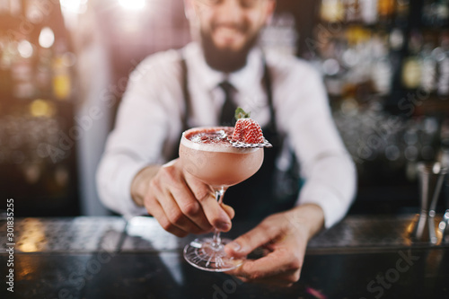 Professional bartender is making cocktail at night club photo