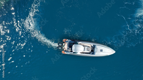Aerial drone  top down photo of luxury rigid inflatable power boat or RIB boat manoeuvring in high speed in open ocean deep blue sea © aerial-drone