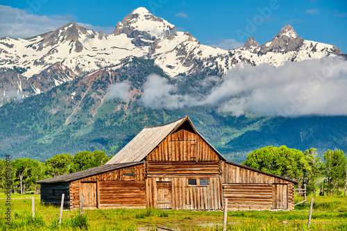 Old mormon barn in Grand Teton Mountains with low clouds. Grand Teton National Park, Wyoming, USA. photo