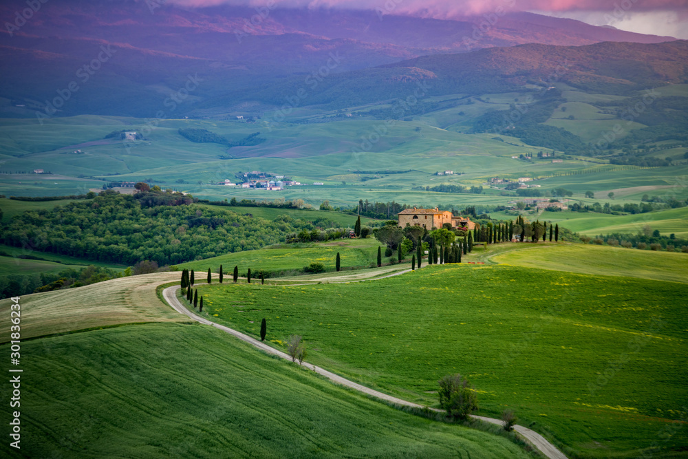 Naklejka premium Farma w Toskanii u podnóża gór, Droga Gladiatora, Włochy, zielone wzgórza podczas zachodu słońca