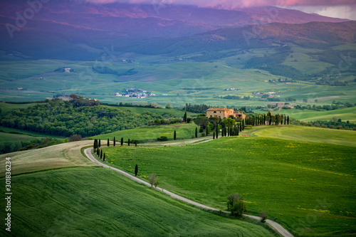 Farma w Toskanii u podnóża gór, Droga Gladiatora, Włochy, zielone wzgórza podczas zachodu słońca