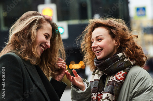 Two girls chatting on the street of the Moscow city happy and laughing photo