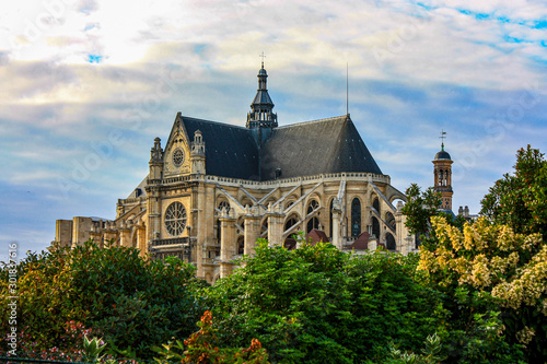 Saint-Eustache gothic church with trees on the foreground. Paris, France