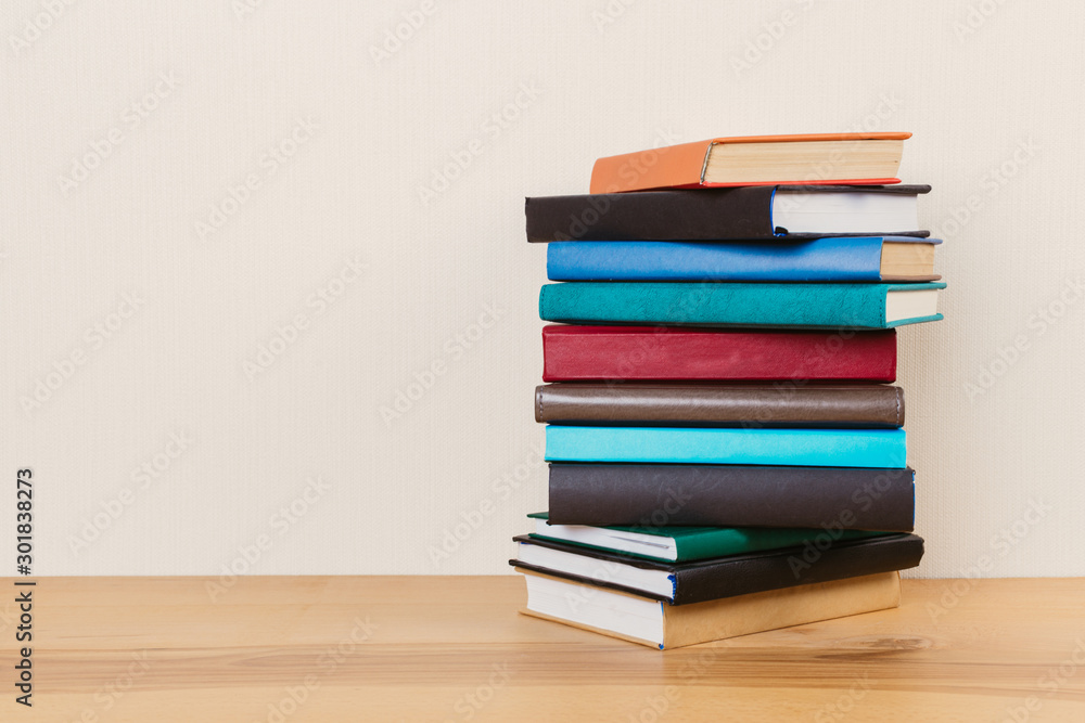 Simple composition of many hardback books, raw of books on wooden table and light background Simple composition of many hardback books, raw of books on wooden table and light background