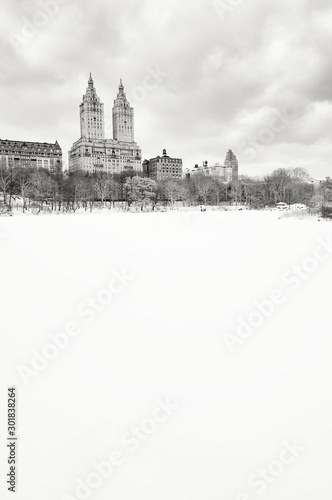 Bleak monochrome view of the Upper West Side skyline above the frozen Central Park Lake after a winter storm in New York City