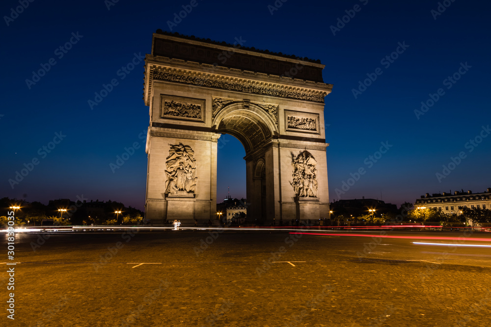 The Arc de Triomphe de l'Étoile illuminated at night, Paris