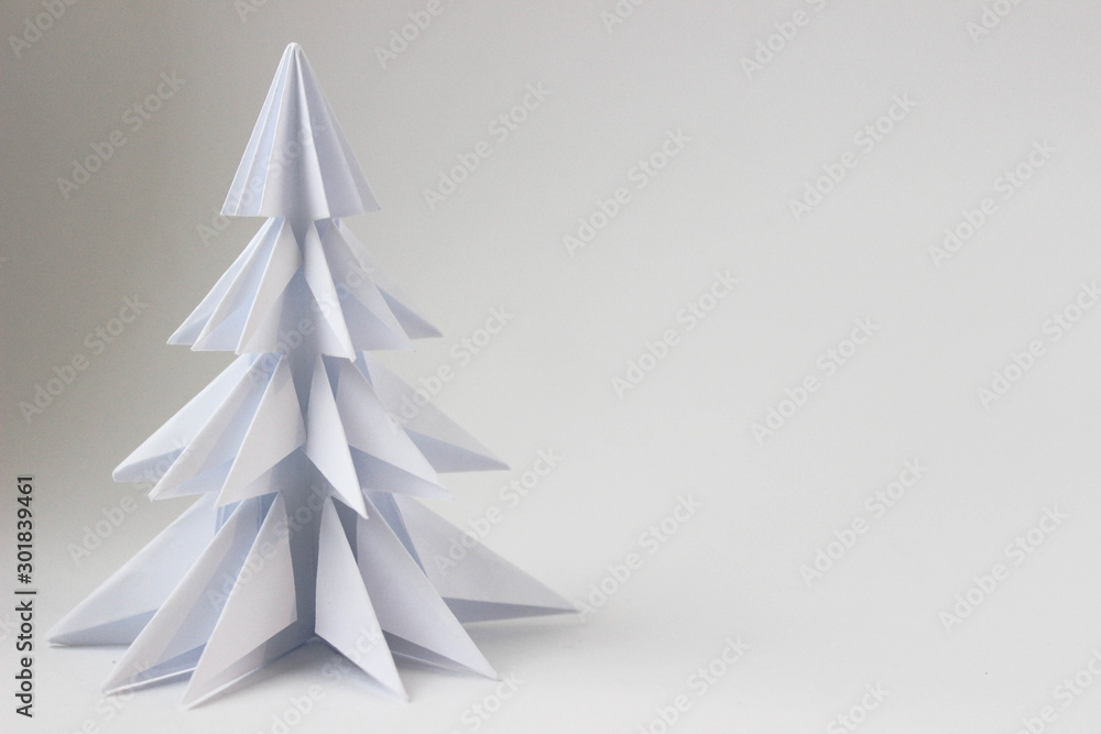 Origami white tree in the left corner of the photo on a white background Origami white tree in the left corner of the photo on a white background