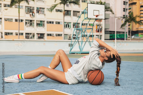 Young stylish woman  is posing on the Choi Hung Estate Basketball Court