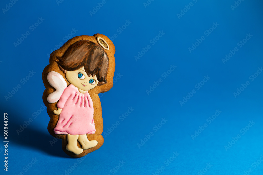 gingerbread cookie of cute little angels on blue background. Traditional Christmas food. Christmas and New Year holiday concept. Copyspace gingerbread cookie of cute little angels on blue background. Traditional Christmas food. Christmas and New Year holiday concept. Copyspace