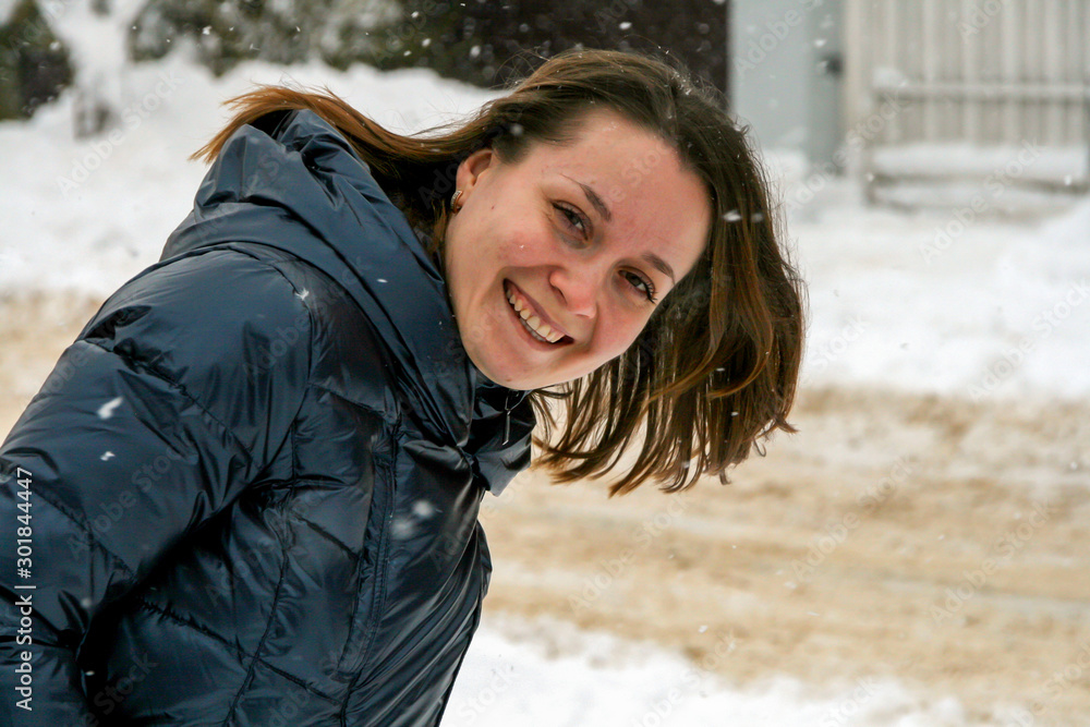 2011.01.02, Maloyaroslavets, Russia. A young beautiful woman lying on the snow, blur and grain effect. Funny winter entertainment.