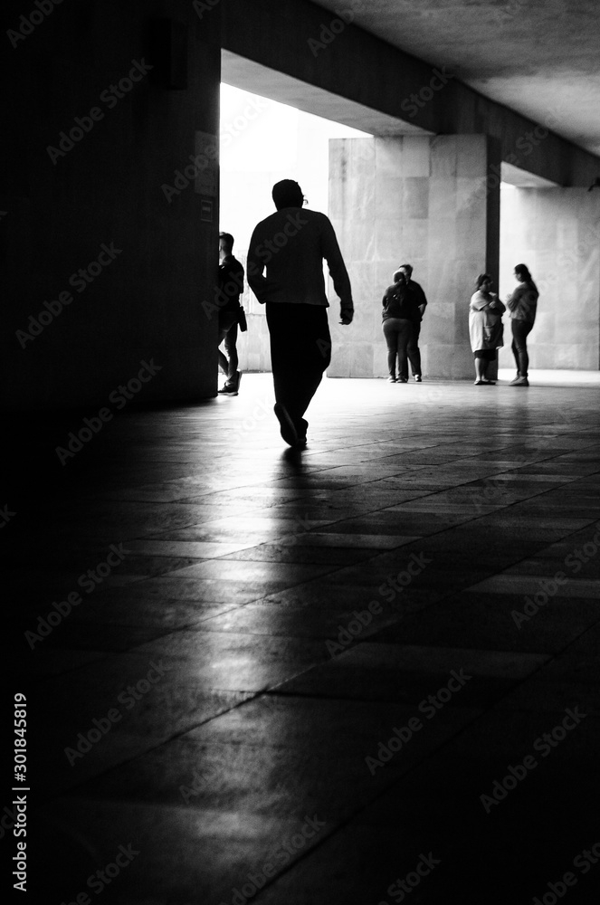 Hombre caminado hacia la luz en medio de otras personas