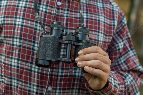 Man holding binoculars in the forest -  © Menta