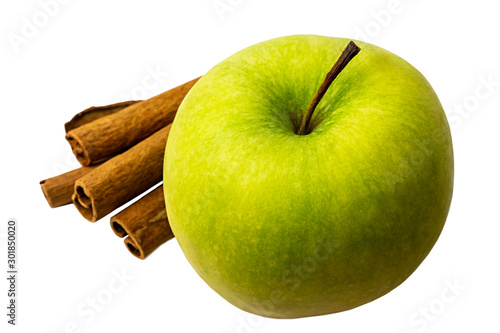 Green apple with cinnamon sticks on white background