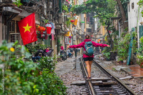 Woman walking on the railway in Hanoi, Vietnam photo