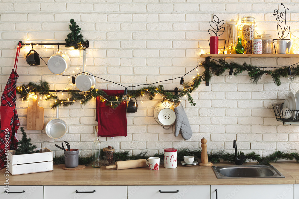 Interior white kitchen with lights and red christmas decorations - obrazy, fototapety, plakaty 
