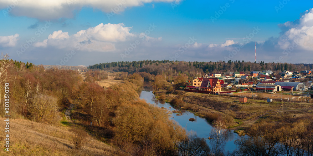 Panoramic view of a modern rural settlement in central Russia near Moscow. Autumn landscape with river and forest Panoramic view of a modern rural settlement in central Russia near Moscow. Autumn landscape with river and forest