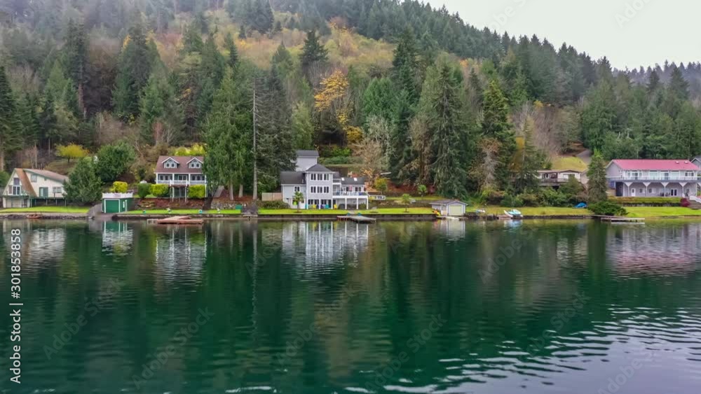Approaching a Pacific Northwest lakefront home set among a forest of evergreen trees Approaching a Pacific Northwest lakefront home set among a forest of evergreen trees