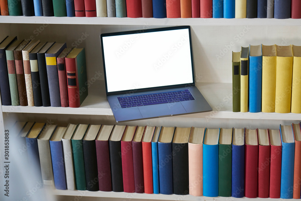 Fototapeta premium Computer between colorful books