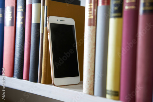 Sideview of mobile phone in bookshelf