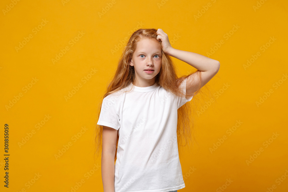 Shocked perplexed little ginger kid girl 12-13 years old in white t-shirt isolated on yellow background children studio portrait. Childhood lifestyle concept. Mock up copy space. Putting hand on head. Shocked perplexed little ginger kid girl 12-13 years old in white t-shirt isolated on yellow background children studio portrait. Childhood lifestyle concept. Mock up copy space. Putting hand on head.