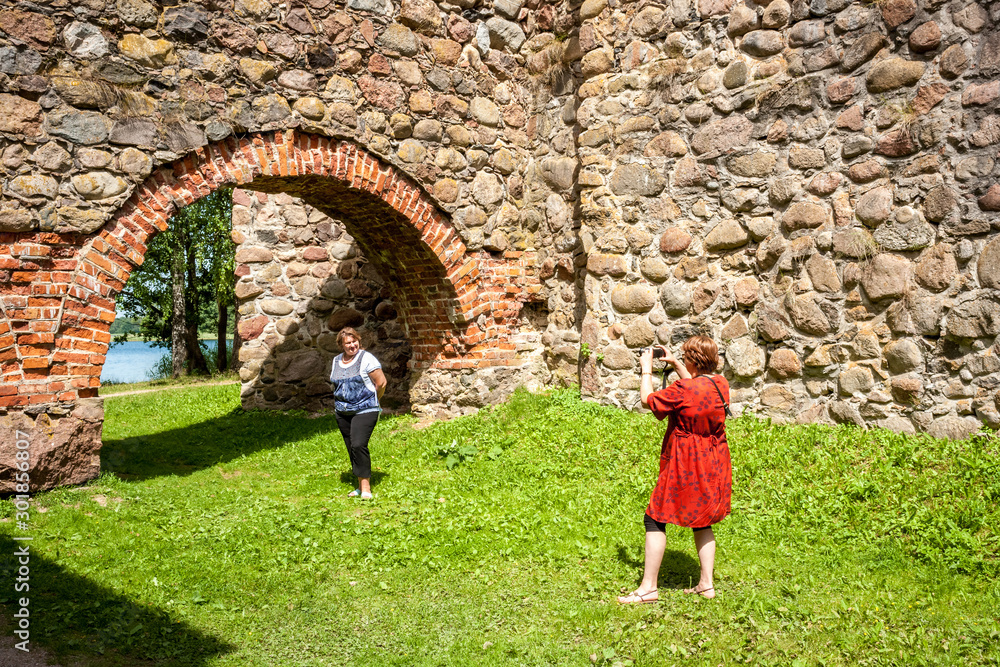 Two Mature female tourists inspect an ancient castle.