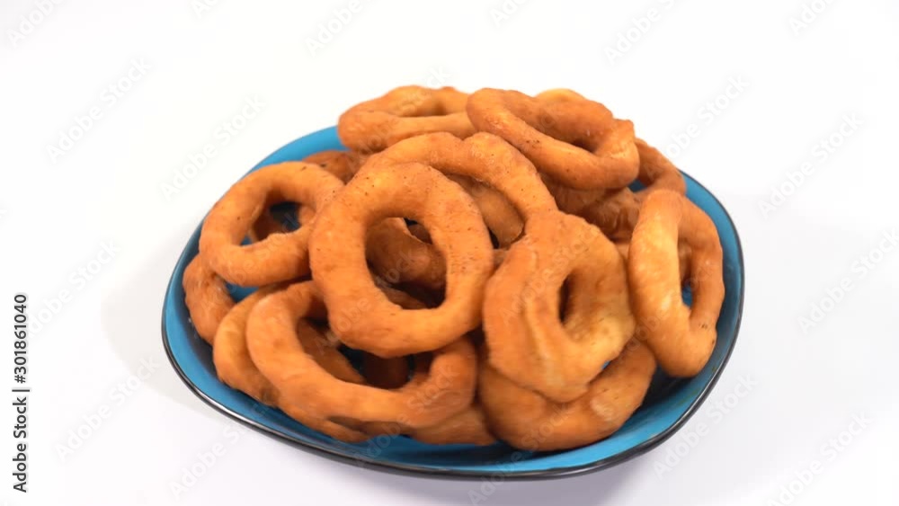A lot of fresh fried doughnuts in a plate on the table spinning in front of the camera A lot of fresh fried doughnuts in a plate on the table spinning in front of the camera