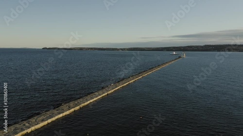 Wallpaper Mural Flying towards the lighthouse at the end of a breakwater as a yacht cruises by AERIAL Torontodigital.ca
