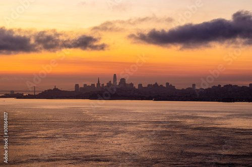 Sunset or sunrise through the clouds, dramatic sky above the city of San Francisco, city in shadow, photo of the horizon taken on the Golden Gate © Andy