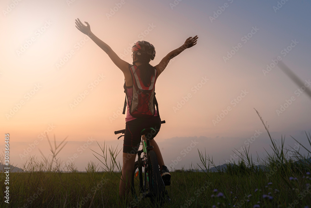 A woman riding a bicycle silhouette At the sunsets, relax at the end of the day A woman riding a bicycle silhouette At the sunsets, relax at the end of the day