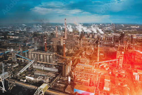 Aerial view of Factory or Plant Industrial Area with many pipes or chimneys with smoke in red sunlight flare. Heavy industry, landscape from drone.