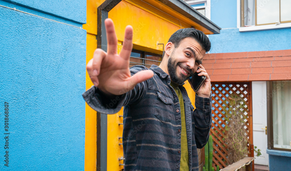 portrait of a young guy talking on the phone portrait of a young guy talking on the phone
