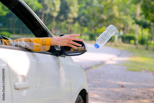 Принти на полотні Woman hand throw clear bottle with blue cap out from car window with the concept human garbage destroy environment