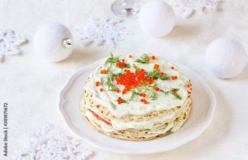 crep cake for Christmas and New Year. Decor with red caviar as New Year balls and dill as sprigs of spruce. Snack cake with salmon, avocado and soft cheese. Festive decor of the table for Christmas.