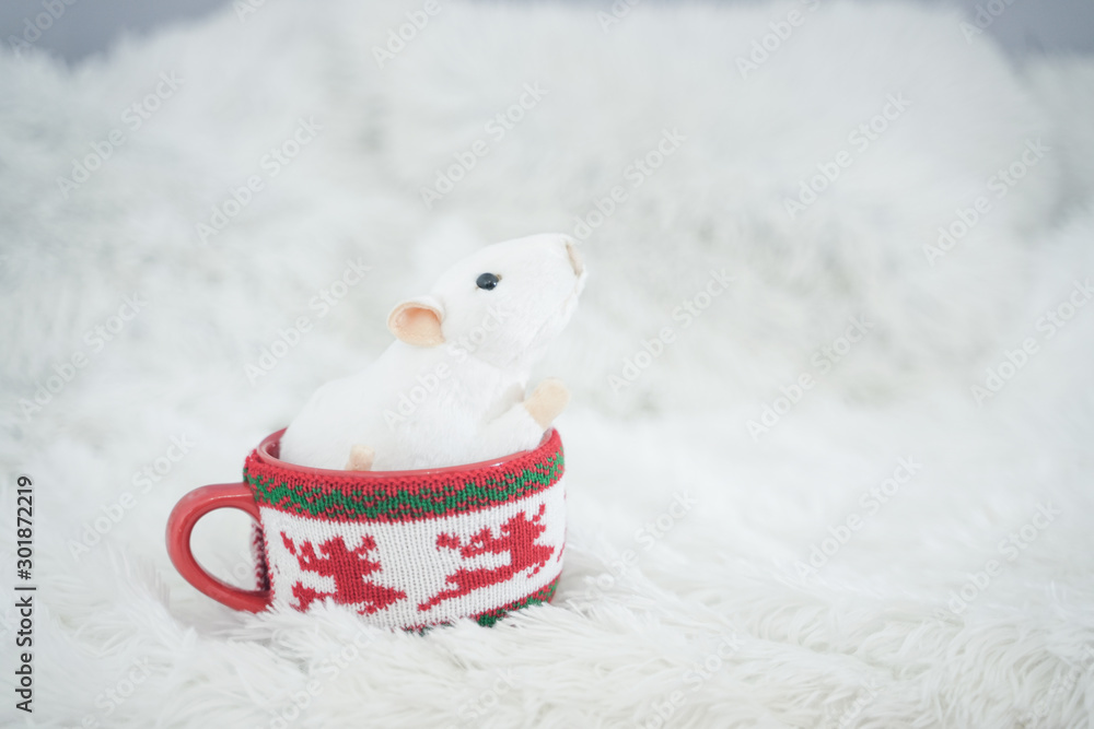 Obraz premium beautiful red mug with trendy sweater on it with white mouse inside. rat as a symbol of the year. nobody. white background.