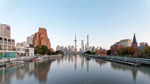 Photography beautiful shanghai bund viewed from suzhou river in evening with moon and blue sky background, including many famous landmarks in Shanghai