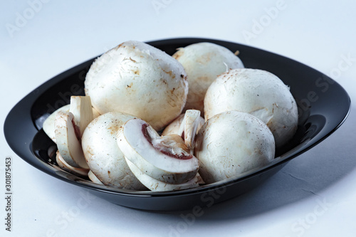  porcini mushrooms, champignons, on a white plate, on a wooden board, on a black plate