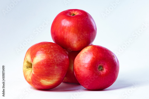 Red apples on a white plate, on a wooden, in a plate