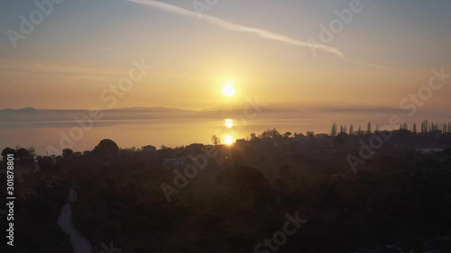 Wallpaper Mural Drone flying above a hazy waterfront town on golden hour sunset with sun reflecting on the misty water surface in Lesvos, Greece. Torontodigital.ca