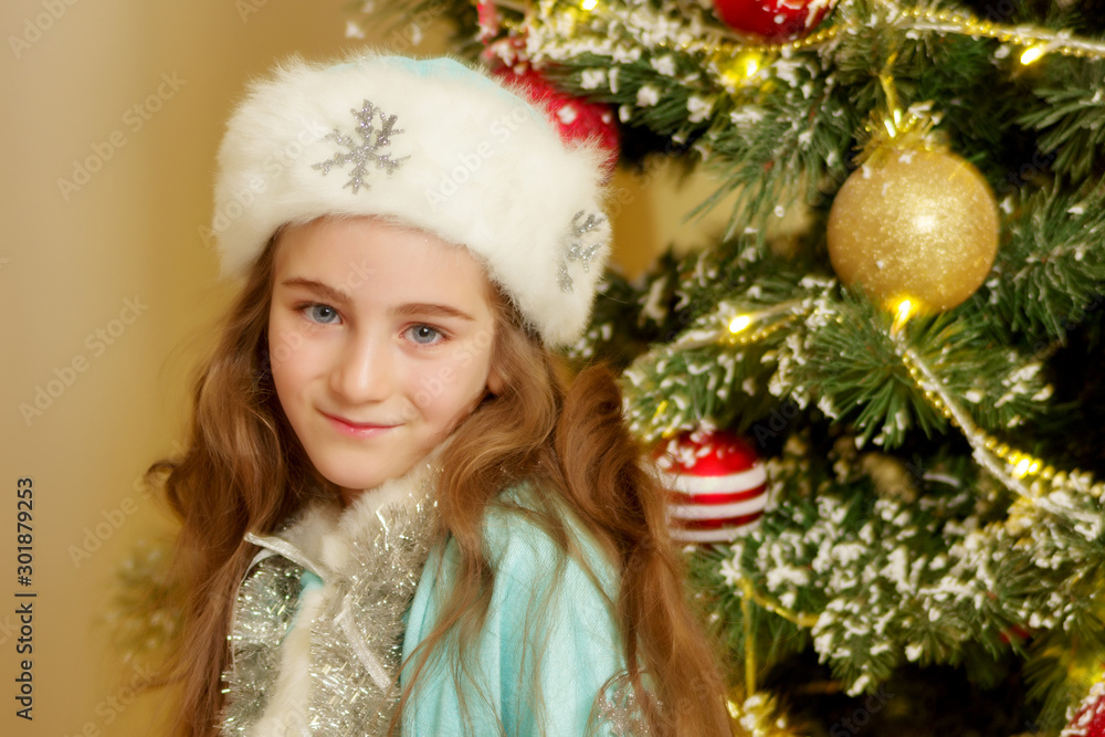 Little girl Snow Maiden near the New Year tree.