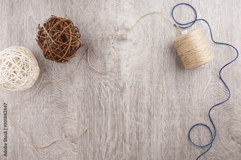 twine and two decorative balls, burlap and coffee mug on light gray wooden background. twine and two decorative balls, burlap and coffee mug on light gray wooden background.
