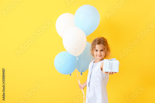 Little girl with balloons a...