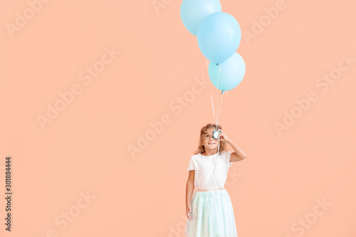 Little girl with balloons a...