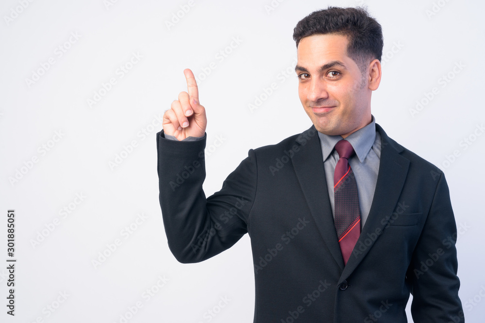Portrait of handsome Persian businessman in suit pointing up Portrait of handsome Persian businessman in suit pointing up