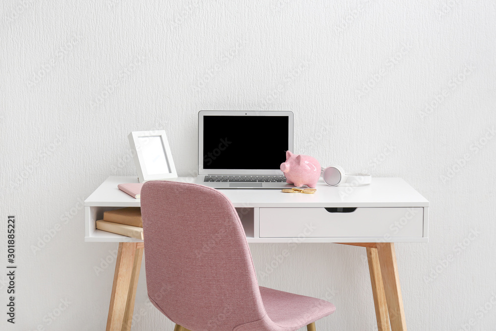 Piggy bank with laptop an coins on table in room Piggy bank with laptop an coins on table in room