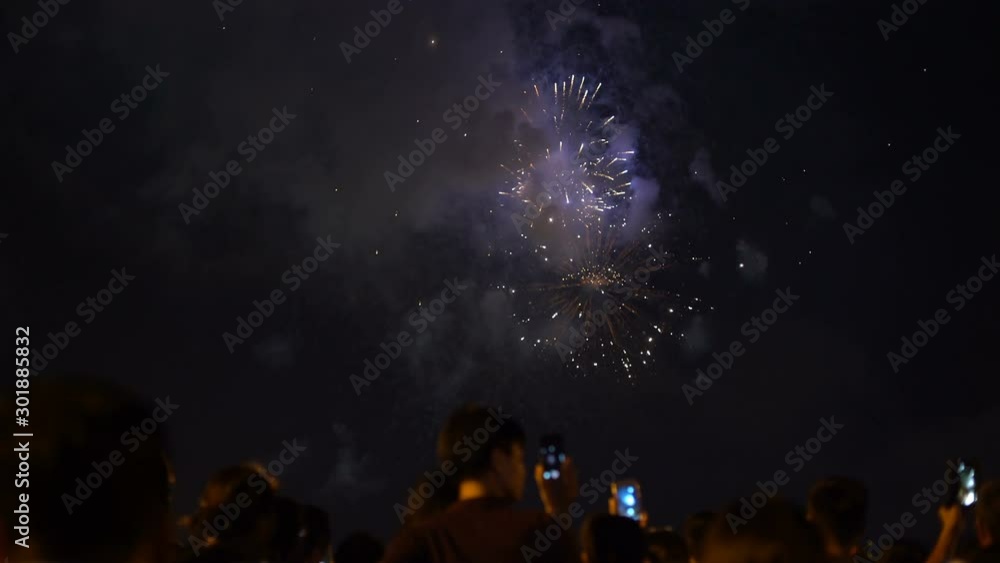 People watching fireworks and recording video with smartphones People watching fireworks and recording video with smartphones