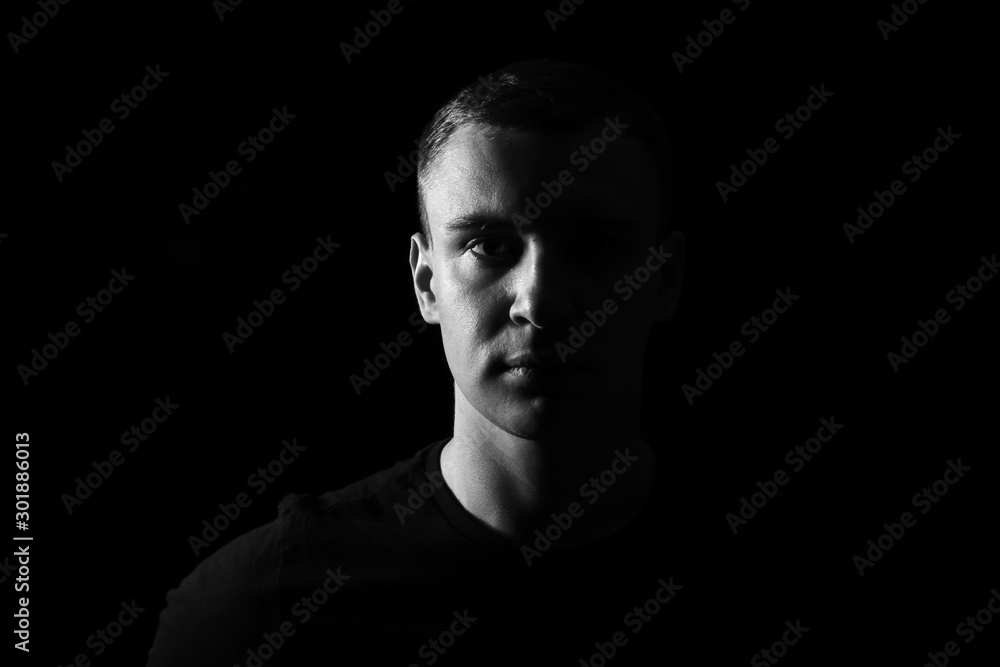 Black and white portrait of young man on dark background Black and white portrait of young man on dark background