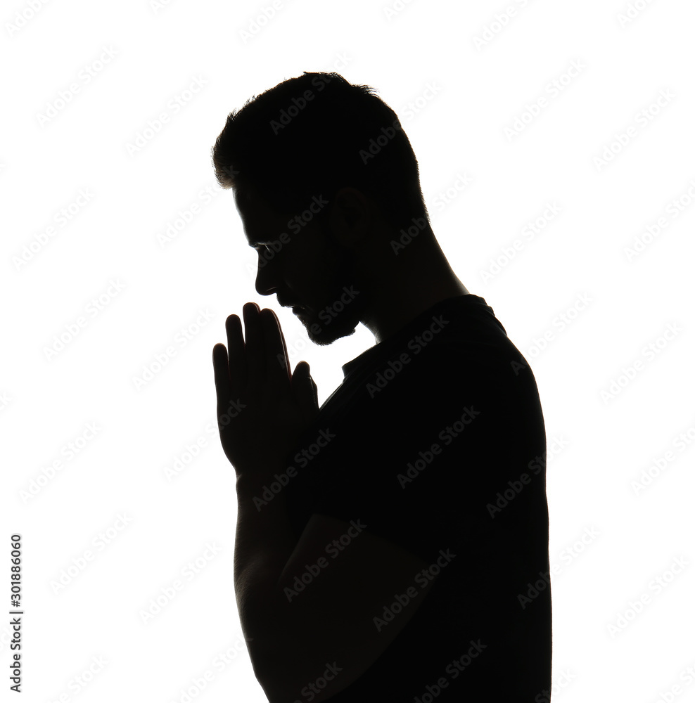 Silhouette of praying young man on white background
