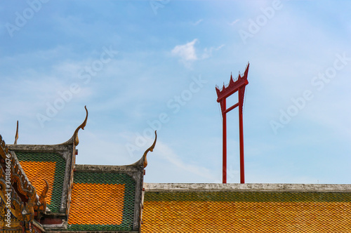 Thai ancient temple church roof with Big red Gaint swing and  sky background. photo