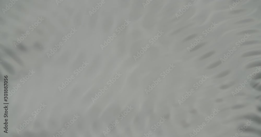 Water forming cymatic patterns and reflecting light. Physical phenomenon between frequency, vibration and liquid. Top shot of fluid surface under influence of acoustic frequency. Water forming cymatic patterns and reflecting light. Physical phenomenon between frequency, vibration and liquid. Top shot of fluid surface under influence of acoustic frequency.