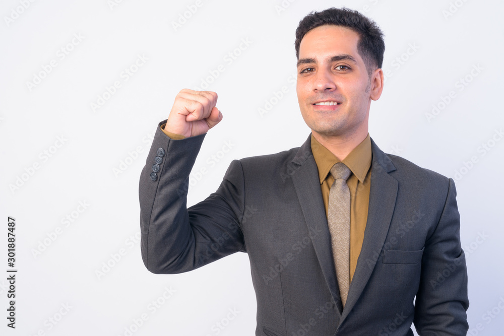 Portrait of happy Persian businessman in suit with fist raised Portrait of happy Persian businessman in suit with fist raised